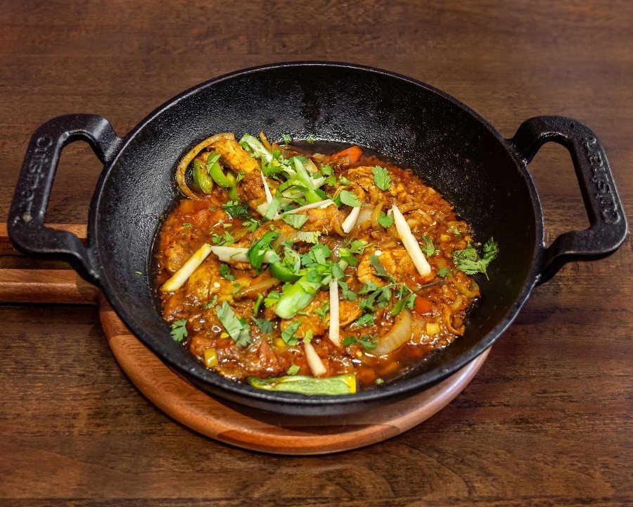 Traditional Pakistani Chicken Karahi wok-cooked with fresh ginger and green chilies.